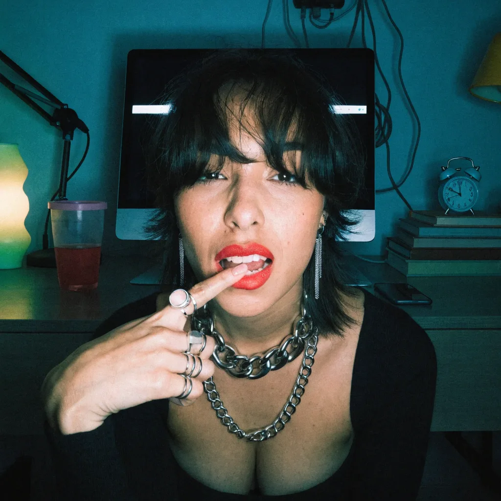 dark-haired woman at her desk at night